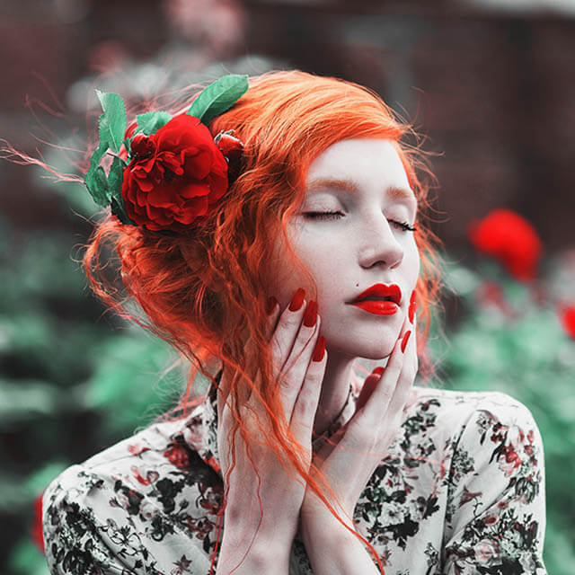 Kobieta z rudymi włosami z kwiatem,